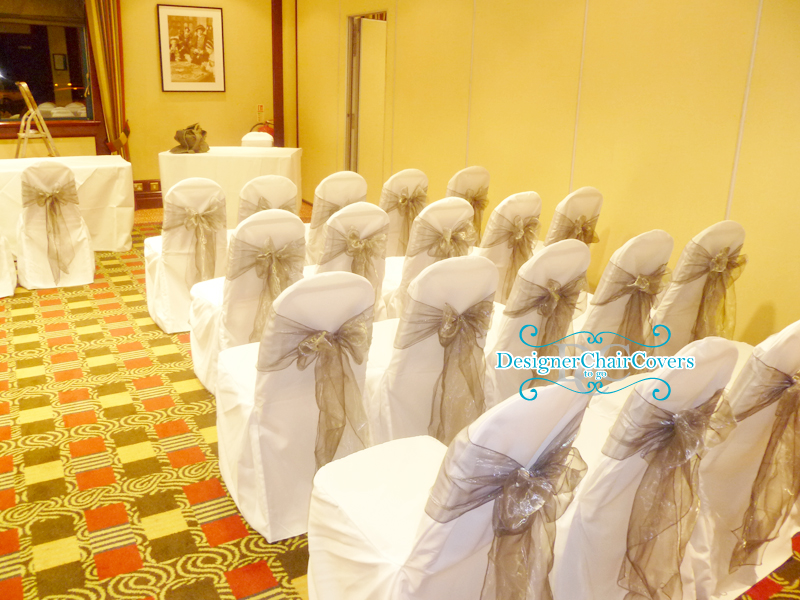 White chair covers with a silver organza sash